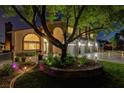 Beautiful home featuring a decorative stone entrance, a landscaped circular flower bed and three-car garage at 7761 Cowboy Trl, Las Vegas, NV 89131