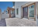 Inviting front entrance with a modern door, stylish tiling, and a charming gated patio area at 9265 Frazer St, Las Vegas, NV 89166