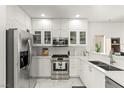 Modern kitchen with stainless steel appliances, white cabinets, and marble countertops at 9613 Eland Ct, Las Vegas, NV 89149