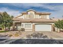 Beautiful two-story home with a well-maintained lawn and a two-car garage, showcasing its curb appeal at 9718 Camino Capistrano Ln, Las Vegas, NV 89147