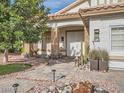 Inviting front entrance with a stone walkway, desert plants, and a decorative double door at 9718 Camino Capistrano Ln, Las Vegas, NV 89147