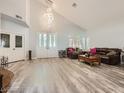 Spacious living room featuring high ceilings, wood flooring, and a modern chandelier for stylish living at 9718 Camino Capistrano Ln, Las Vegas, NV 89147
