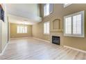 Bright living room with tall windows, a fireplace, and wood flooring at 11478 Bargetto Ct, Las Vegas, NV 89141