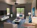 Bright living room with ceiling fan, neutral tones and sliding door access to the outside at 1396 Couperin Dr, Henderson, NV 89052