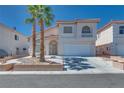 Charming two-story home with a two car garage, desert landscaping, and two palm trees at 1551 Echo Falls Ave, Las Vegas, NV 89183