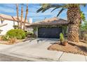 Inviting single-story home with lush landscaping, including mature palm trees, adding curb appeal to the desert property at 1803 Candle Bright Dr, Henderson, NV 89074