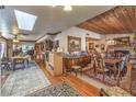 Open-concept dining room and living area with hardwood floors, wood ceiling, and a fireplace at 2045 S Tenaya Way, Las Vegas, NV 89117