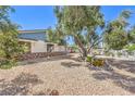 Landscaped side yard showcasing drought-tolerant landscaping, mature trees, and a rock garden at 2045 S Tenaya Way, Las Vegas, NV 89117