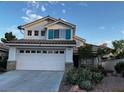 Two-story home with a two-car garage, tile roof, and charming desert-style landscaping at 2419 Pebble Springs Ct, Henderson, NV 89074
