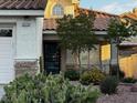 Charming single-story home featuring a tile roof, landscaped yard, and covered porch with stone accents at 2419 Pebble Springs Ct, Henderson, NV 89074