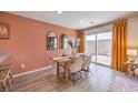 Dining area features a wooden table, stylish chairs, and sliding doors for natural light at 2514 Petunia Garden Ave # 226, North Las Vegas, NV 89081
