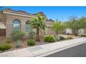 Charming house with desert landscaping, palm trees, and an attached two car garage at 26 Costa Tropical Dr, Henderson, NV 89011