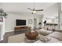 Inviting living room with modern furnishings, a ceiling fan, and seamless flow to the kitchen at 3053 Anchor Chain Dr, Las Vegas, NV 89128