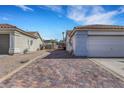 View of the side of a home with access to the backyard through an iron gate and a paved driveway at 341 Waterwheel Falls Dr, Henderson, NV 89015