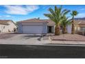 Attractive single-story home with a paved driveway, desert landscaping, and mature palm trees at 341 Waterwheel Falls Dr, Henderson, NV 89015