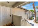 Exterior shot of front door with welcome mat, stucco walls, and views of the complex at 3420 Winterhaven St # 202, Las Vegas, NV 89108