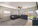 Bright living room featuring two sofas, plush carpet, and sliding glass door to the backyard at 4780 Lorenzo Way, Pahrump, NV 89061