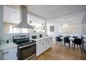 Modern kitchen with stainless steel appliances, white cabinetry, and an open floorplan dining area at 6301 Garwood Ave, Las Vegas, NV 89107