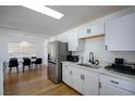 Updated kitchen with stainless steel appliances, white cabinets, and adjacent dining area at 6301 Garwood Ave, Las Vegas, NV 89107