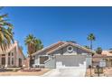 Charming single-story home with a well-maintained front yard and a two-car garage at 6961 Ray Charles Ln, Las Vegas, NV 89119