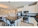Modern kitchen featuring stainless steel appliances, granite countertops, white cabinetry, and pendant lighting at 8490 Classique Ave # 101, Las Vegas, NV 89178