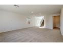 Large, carpeted living room with big windows and bright walls offers ample natural light at 89 Via Franello, Henderson, NV 89011
