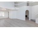 Open concept living space with soaring ceilings, a staircase, and light wood-look flooring at 92 Sea Holly Way, Henderson, NV 89074