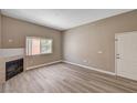 Open living area featuring a cozy fireplace and new wood-style flooring at 9303 Gilcrease Ave # 2217, Las Vegas, NV 89149