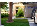 Well-manicured lawn and landscaping leading up to the front entrance of a two-story home at 9440 Grenville Ave, Las Vegas, NV 89134