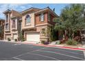 Charming townhome with a two-car garage and landscaped front, set on a sunny day at 9975 Sand Key St, Las Vegas, NV 89178