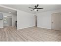 Open living room featuring sleek laminate floors, a modern ceiling fan, and fresh white paint at 1417 Dogwood Ave, North Las Vegas, NV 89030