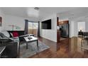 Cozy living room with a modern dark-colored sofa, a flat-screen TV, and hardwood floors at 2451 N Rainbow Blvd # 2043, Las Vegas, NV 89108