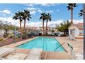 Community pool with lounge chairs and palm trees offering a relaxing outdoor space at 3322 Dragon Fly St, North Las Vegas, NV 89032