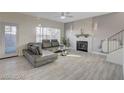 Bright living room with a decorative fireplace, a gray leather sectional, and large windows for natural light at 3412 Adventure Ct, Las Vegas, NV 89129