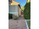 This house features a side yard, neutral exterior, with a metal gate separating the front and back at 3416 Mountain Park St, Las Vegas, NV 89129