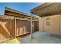 Enclosed patio with a wooden fence and partial roof, with a door that provides access to the house at 3441 Villa Way, Las Vegas, NV 89120