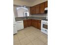 Traditional kitchen featuring wood cabinets, granite countertops, tiled floor, and modern white appliances at 520 Prince Alan Ct, Las Vegas, NV 89110