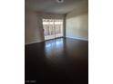 Bright living room featuring dark hardwood floors and sliding glass doors leading to an outdoor patio at 520 Prince Alan Ct, Las Vegas, NV 89110