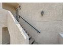 Close up of entry steps highlighting the textured stucco and a dark railing leading to the front door at 605 Devonhall St # 201, Las Vegas, NV 89145