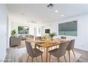Bright and airy dining room with wood flooring, large window, and seating for six at 669 Elliot Peak Ave, Las Vegas, NV 89183