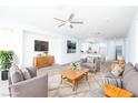 Open concept living room with modern furnishings, wood flooring and an adjacent kitchen at 669 Elliot Peak Ave, Las Vegas, NV 89183