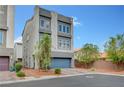 Contemporary two-story home featuring a grey stucco facade, a two-car garage, and a well-manicured front yard at 7756 Seville Estates Ct, Las Vegas, NV 89113