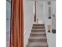 View of a carpeted staircase with white railings, ascending towards a well-lit landing and upper level of the home at 7756 Seville Estates Ct, Las Vegas, NV 89113