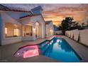 Backyard featuring a beautiful pool, spa and outdoor seating area with a lovely sunset at 8104 Bay Harbor Dr, Las Vegas, NV 89128