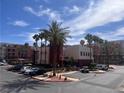 Exterior of community buildings with palm trees and parking, under a blue sky at 87 E Agate Ave # 202, Las Vegas, NV 89123