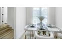 Elegant dining room with a modern table setting, white chairs, and plenty of natural light at 9078 Hilverson Ave, Las Vegas, NV 89148