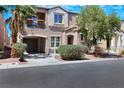 Lovely home showcasing a private balcony, attached garage, and welcoming front yard surrounded by greenery, trees, and blue sky at 9078 Hilverson Ave, Las Vegas, NV 89148