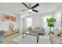 Bright living room featuring a ceiling fan, neutral sofa, large windows, and modern decor at 9078 Hilverson Ave, Las Vegas, NV 89148