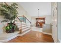 Spacious foyer with hardwood floors, staircase, large decorative plants, and high ceilings at 9436 Darwell Dr, Las Vegas, NV 89117