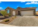Inviting single-story home with desert landscaping, retaining wall, and spacious two-car garage at 977 Majestic Vw, Mesquite, NV 89034